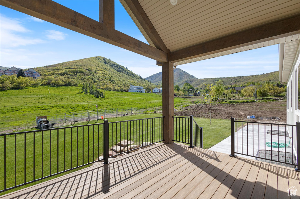 Deck with a mountain view, a view of countryside, and a yard