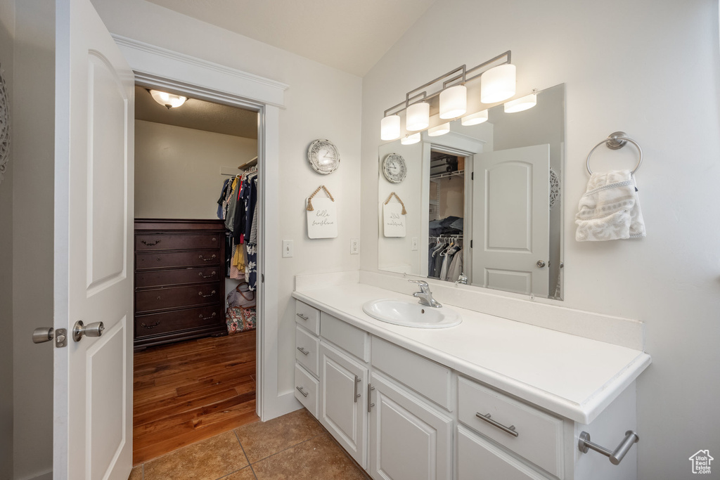 Bathroom with vanity, a walk in closet, and tile patterned floors
