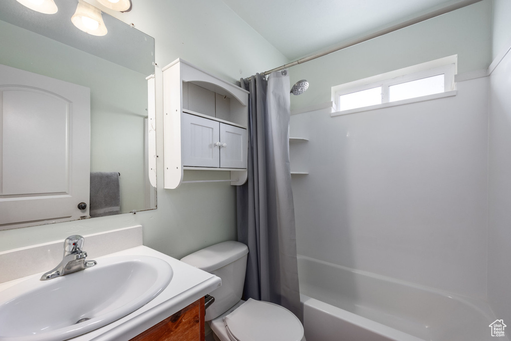 Full bath featuring toilet, vanity, and shower / bath combo