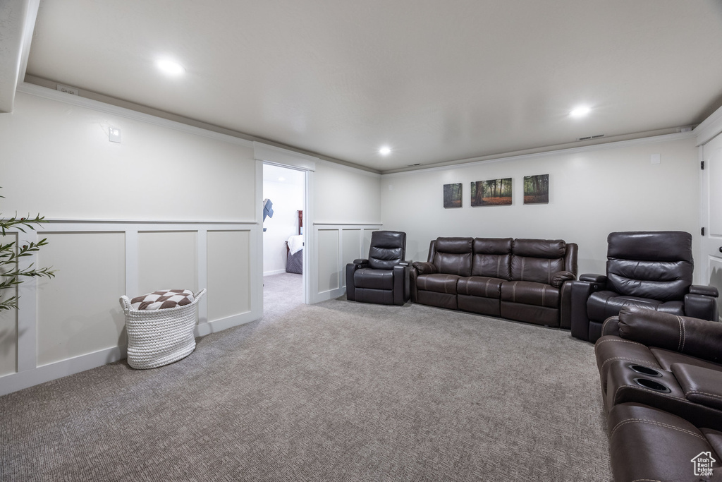 Carpeted cinema featuring recessed lighting, wainscoting, and a decorative wall