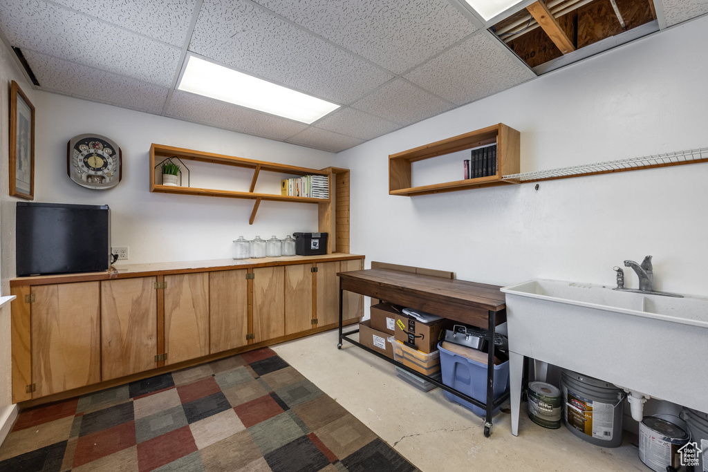 Basement featuring a paneled ceiling and a sink