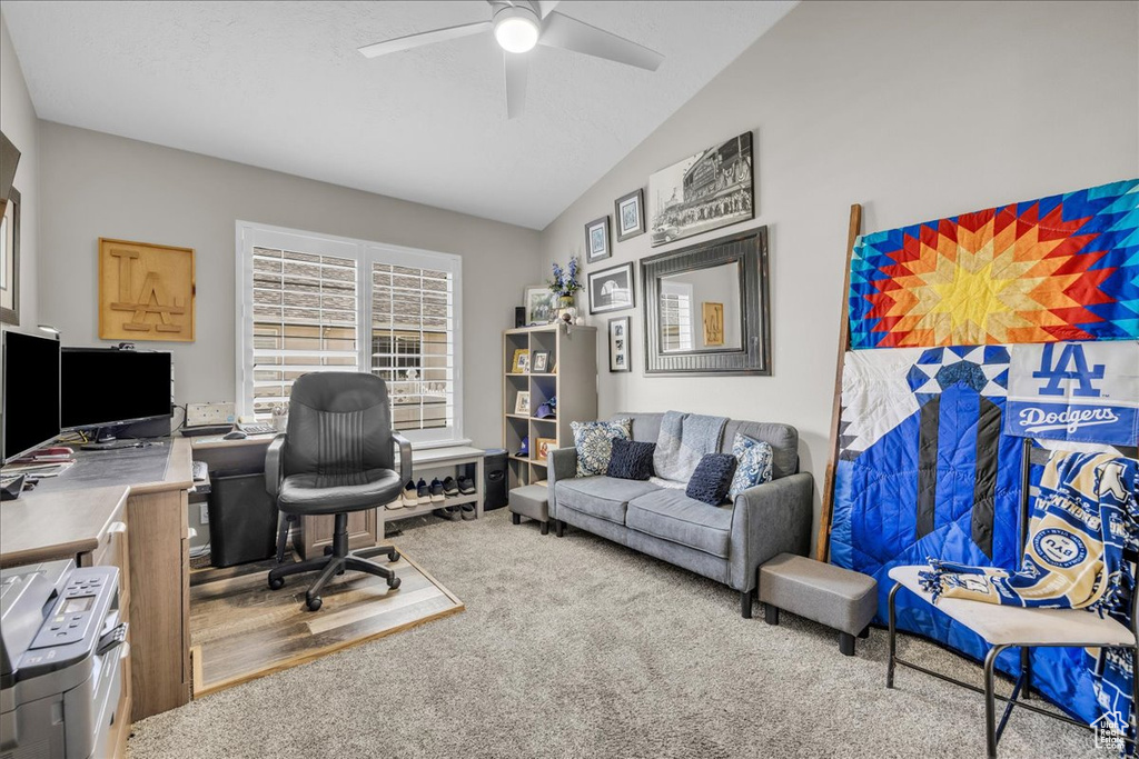 Office space with a ceiling fan, carpet, and lofted ceiling