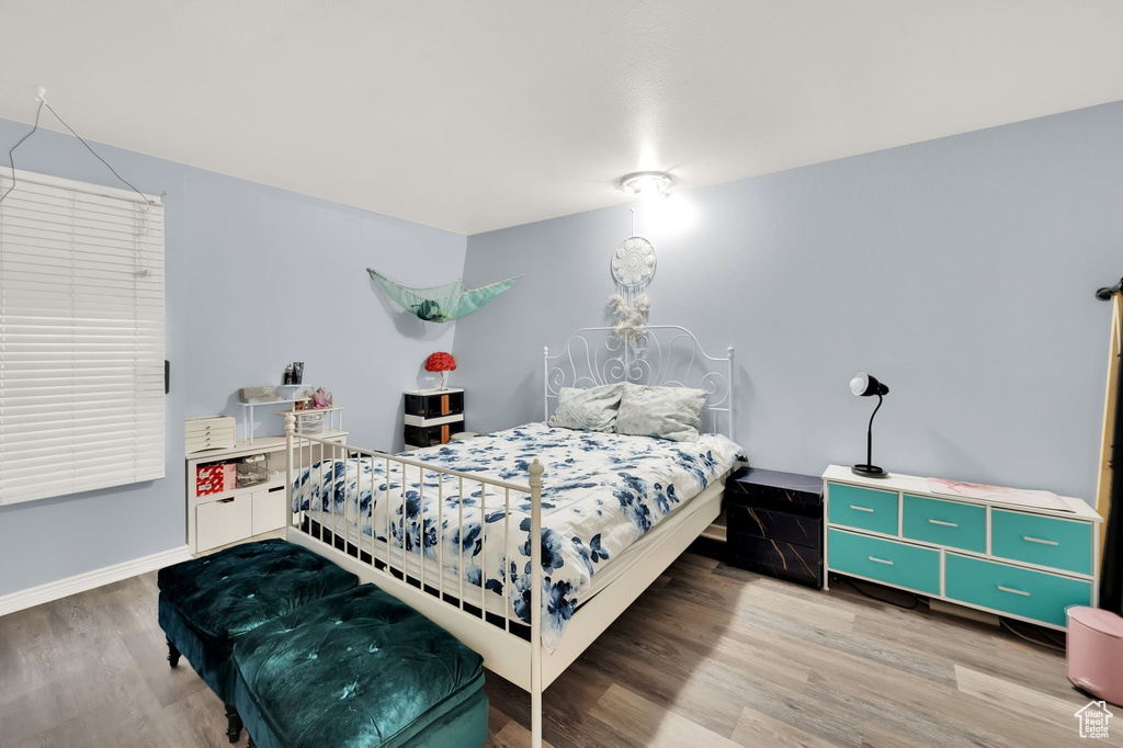 Bedroom with wood finished floors and baseboards