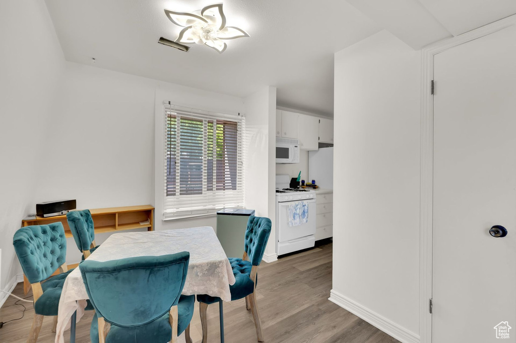 Dining room with baseboards, light wood-style floors, and a desk