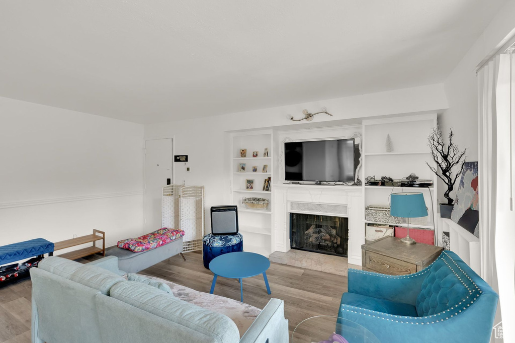 Living room featuring wood finished floors and a fireplace with raised hearth