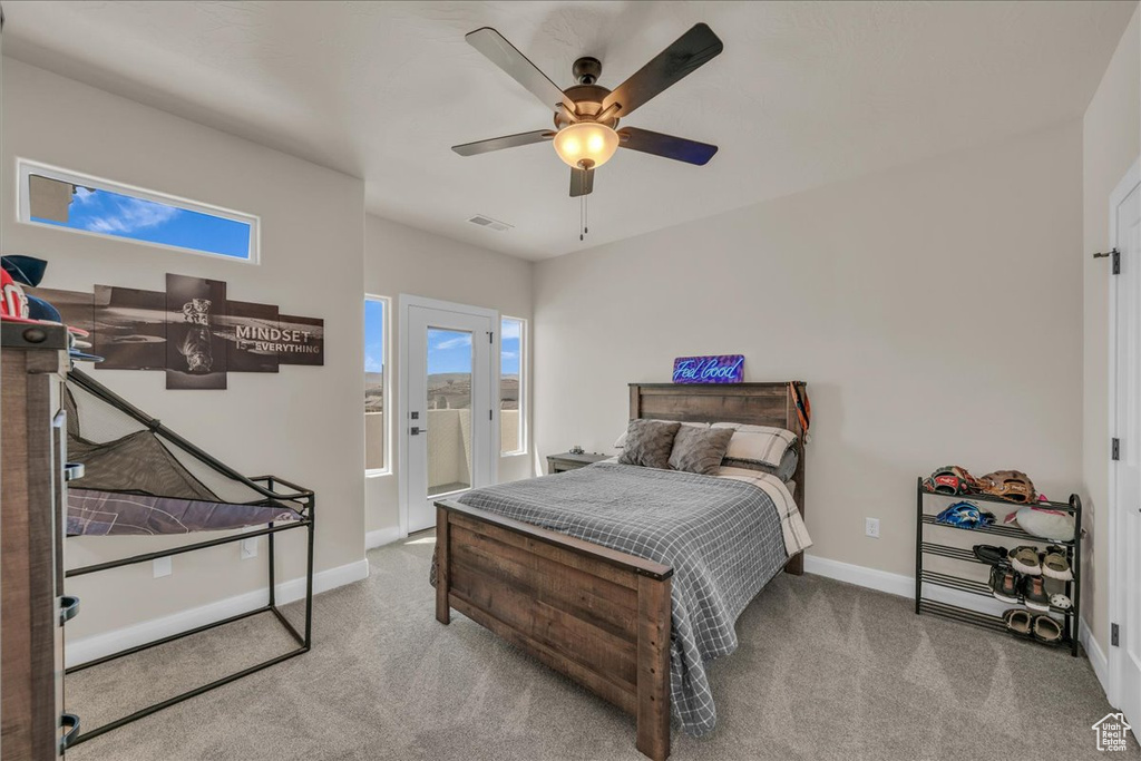 Carpeted bedroom featuring baseboards, a ceiling fan, and access to exterior