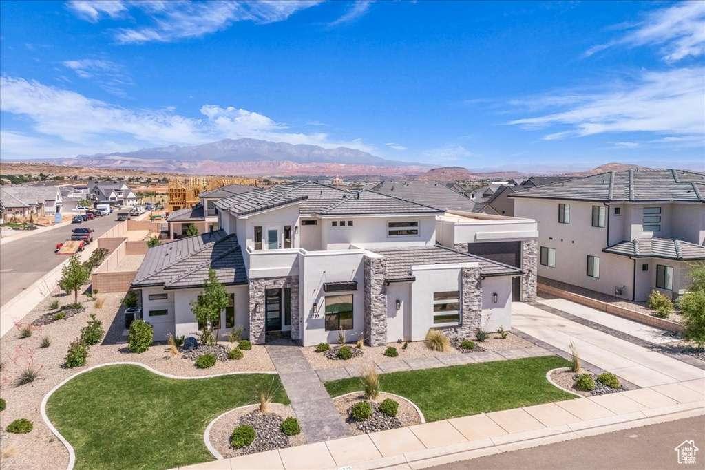 Contemporary home featuring stone siding, stucco siding, a residential view, and a tile roof