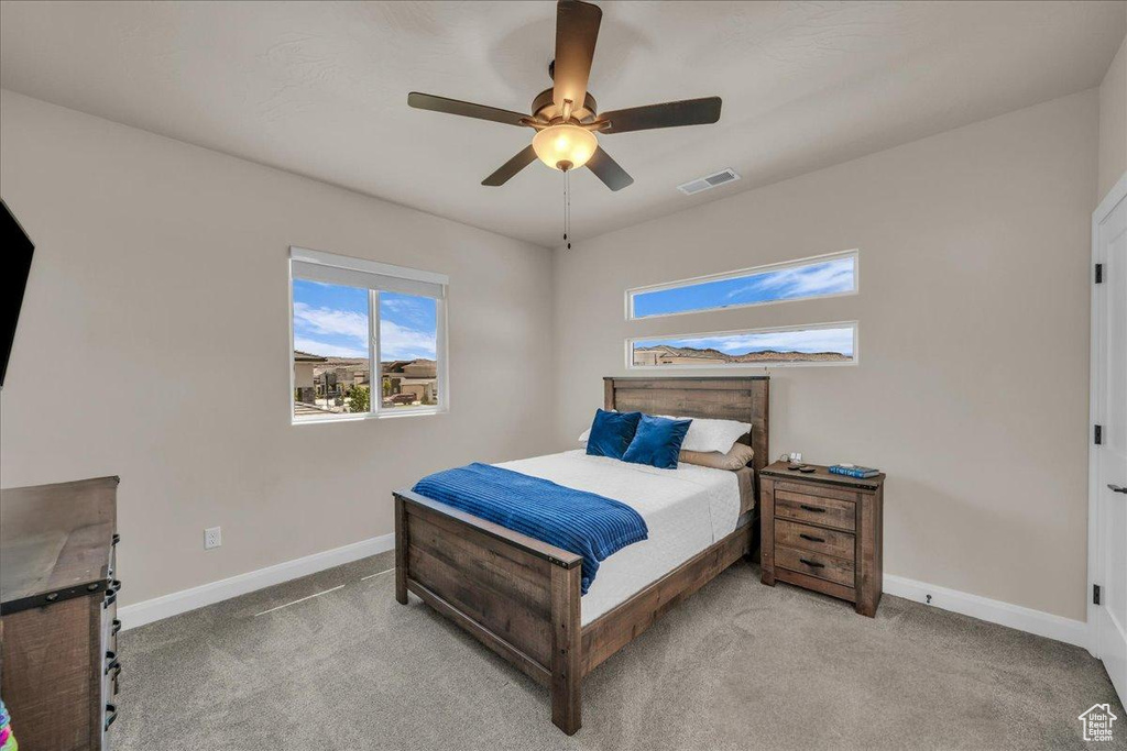 Bedroom with baseboards, light carpet, and ceiling fan