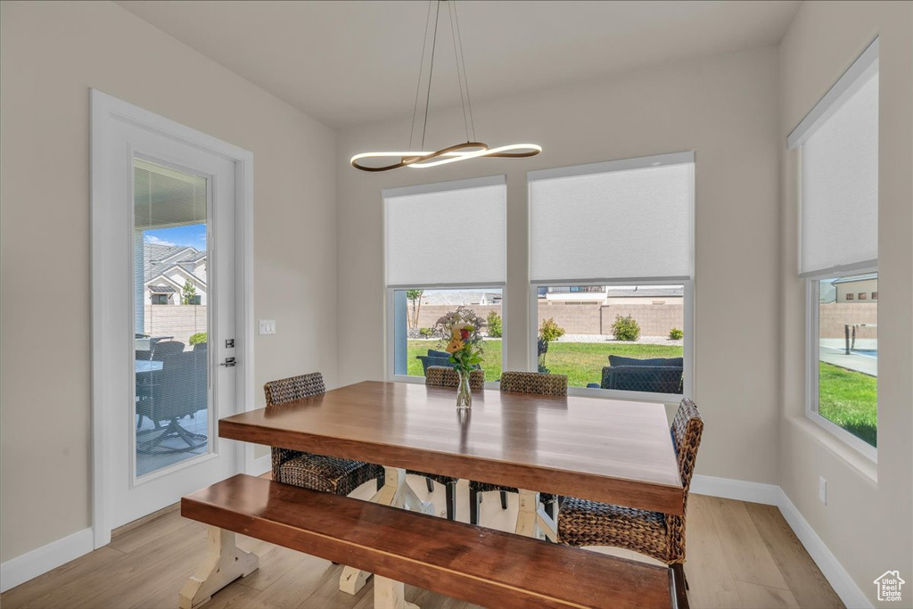 Dining space with plenty of natural light, light wood-style floors, and baseboards