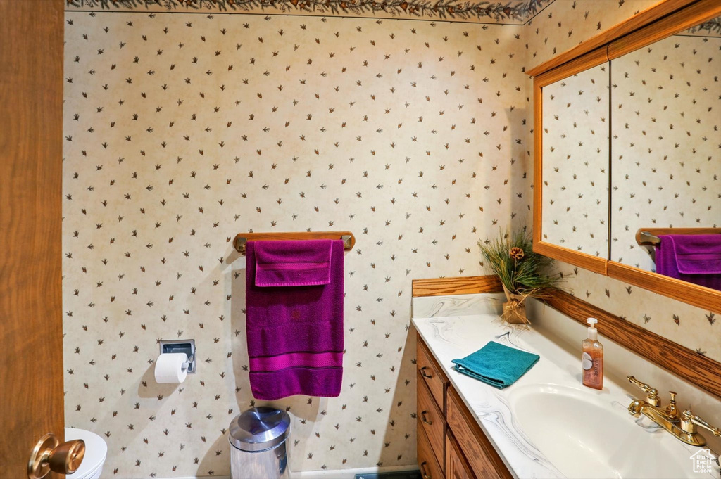Bathroom featuring vanity and wallpapered walls