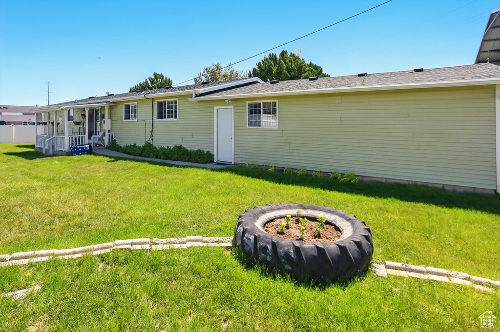 Rear view of property with a yard