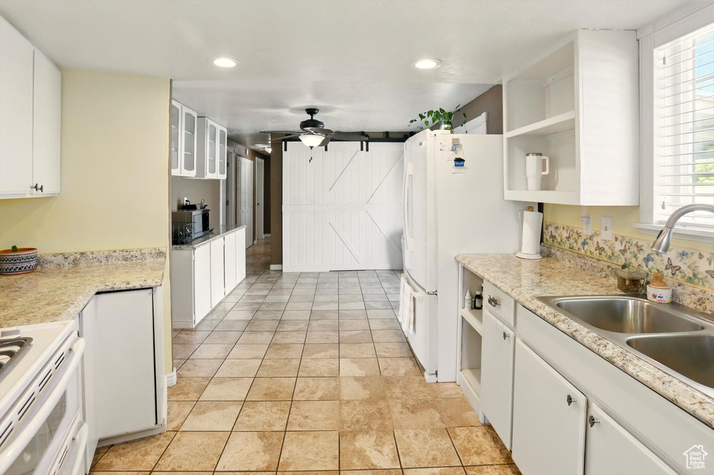 Kitchen featuring open shelves, a sink, white appliances, white cabinetry, and ceiling fan