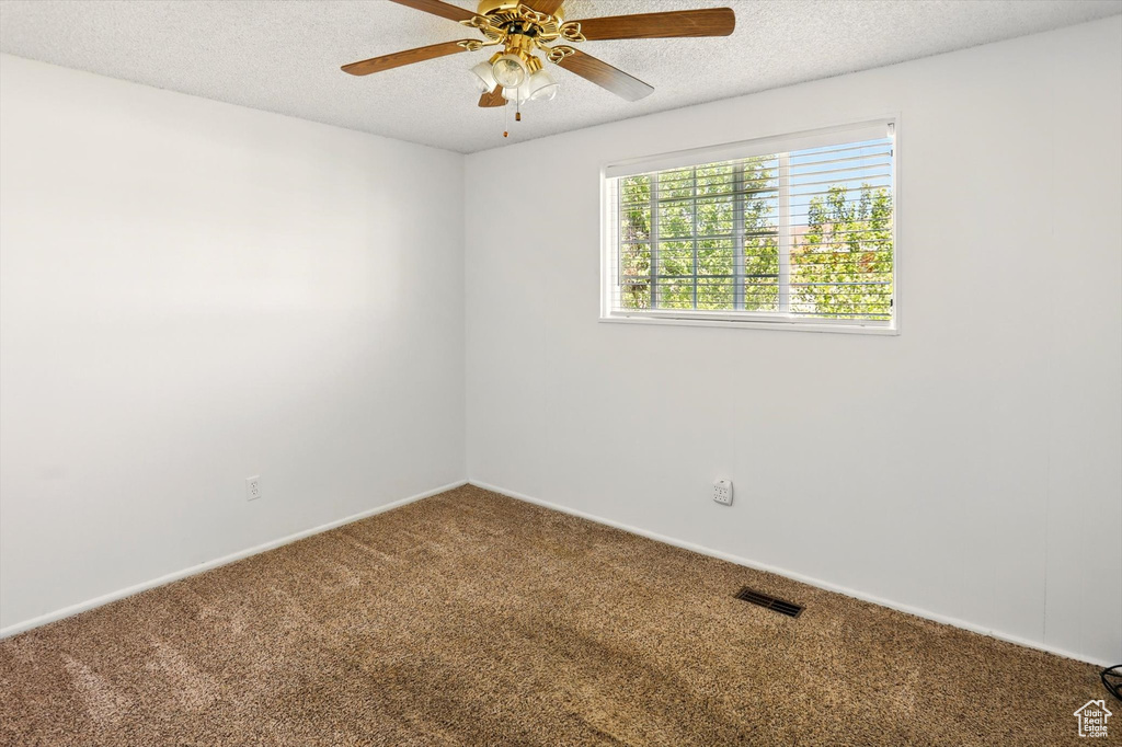 Unfurnished room with carpet floors, a textured ceiling, ceiling fan, and baseboards