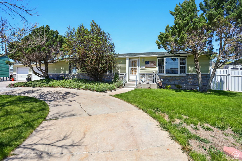 View of front of house featuring stone siding, a garage, and driveway