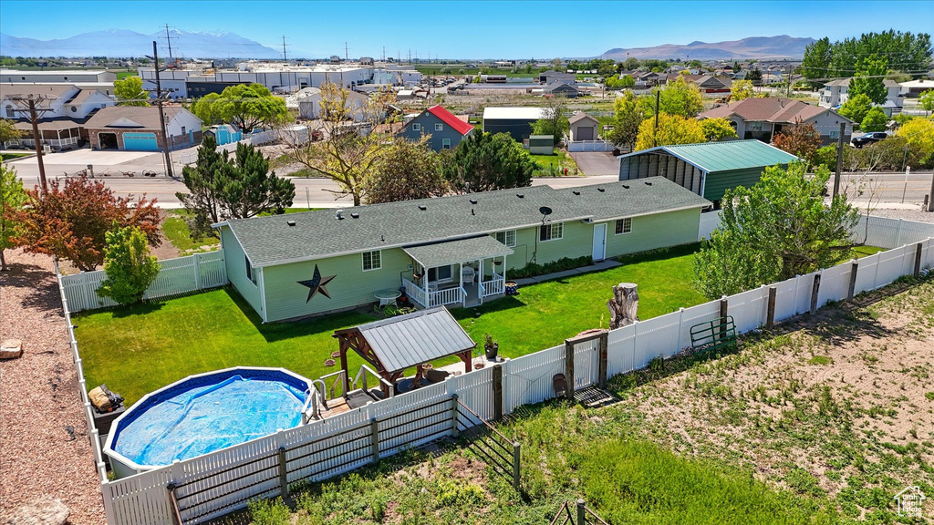 Aerial view of residential area featuring a mountainous background and a pool