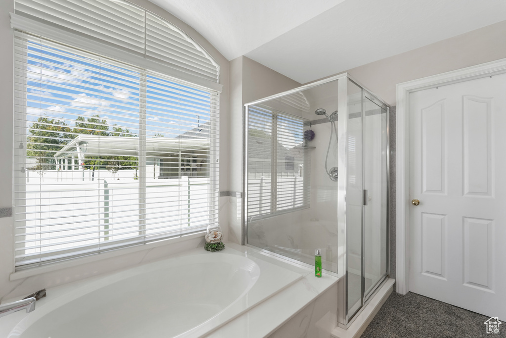 Full bath with a shower stall and a bath