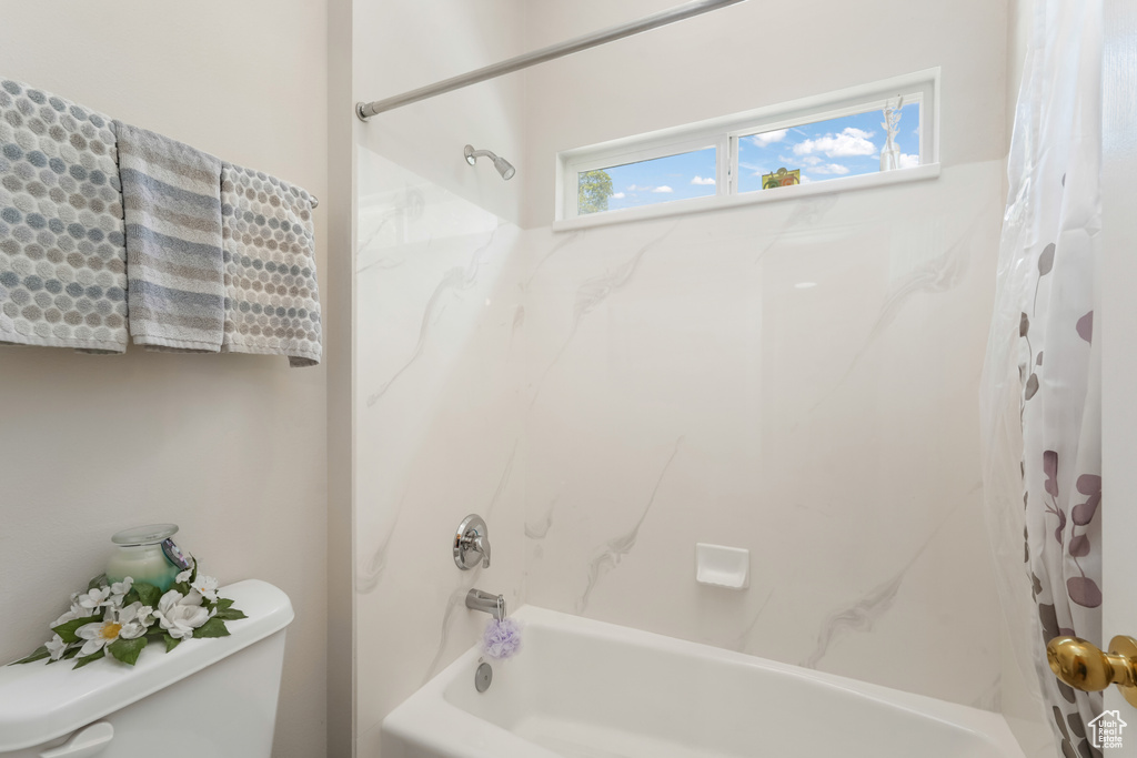 Bathroom with shower / bath combination with curtain and toilet
