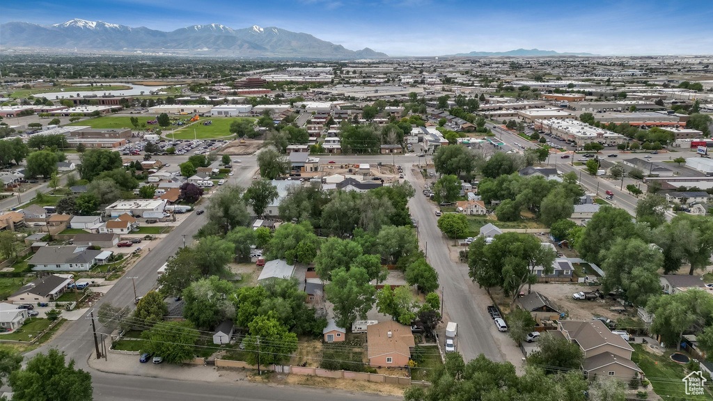 Aerial view of property and surrounding area featuring a mountain backdrop