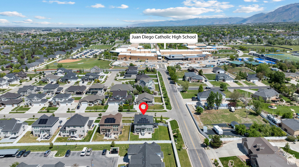 Aerial view of property and surrounding area with a mountainous background and nearby suburban area