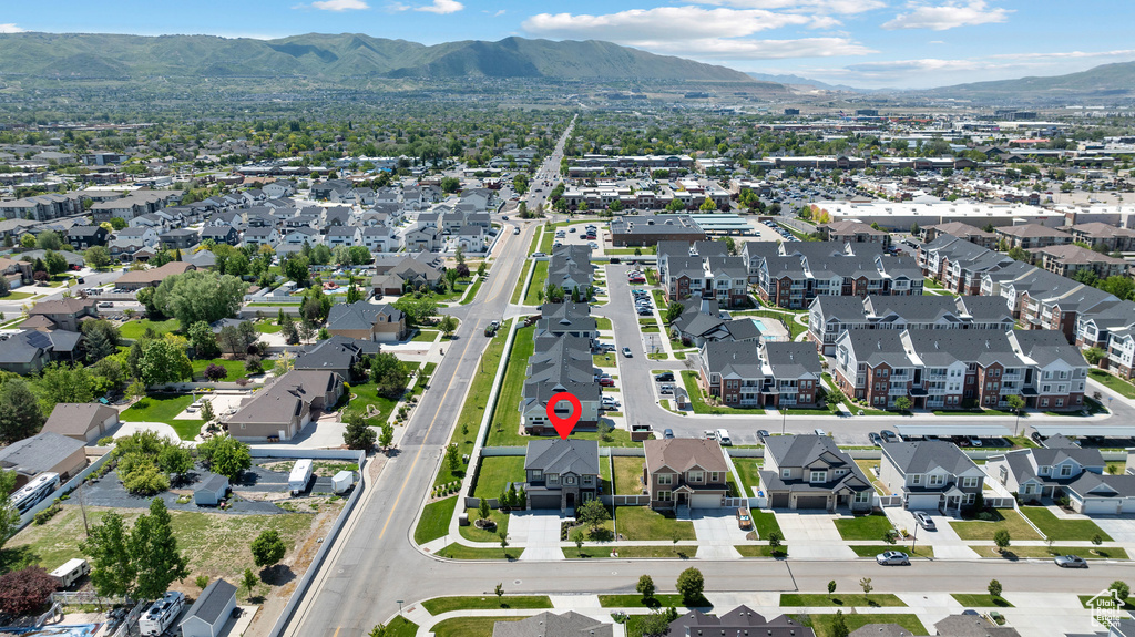 Aerial view of property and surrounding area with mountains and nearby suburban area