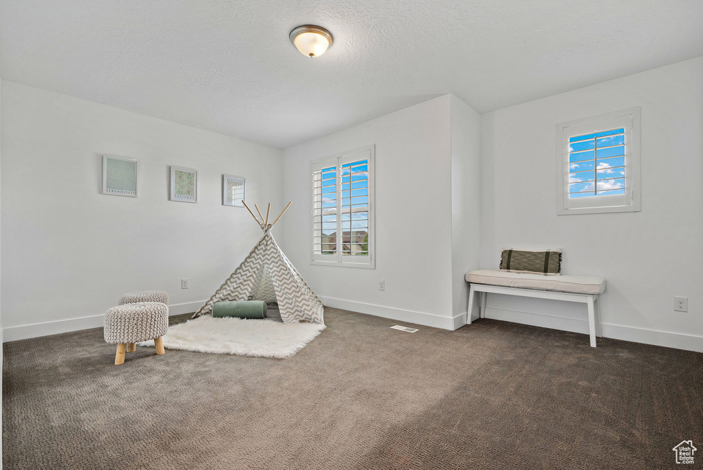 Rec room featuring dark carpet and baseboards