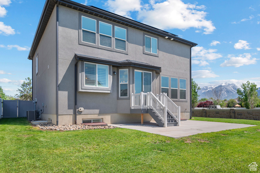 Back of property with stucco siding, a patio area, a gate, and a mountain view