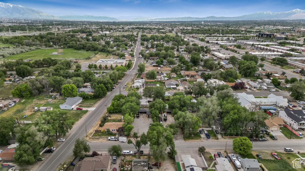 Aerial view of property and surrounding area featuring a mountainous background