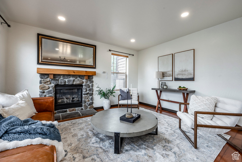 Living room with wood finished floors, a fireplace, recessed lighting, and baseboards
