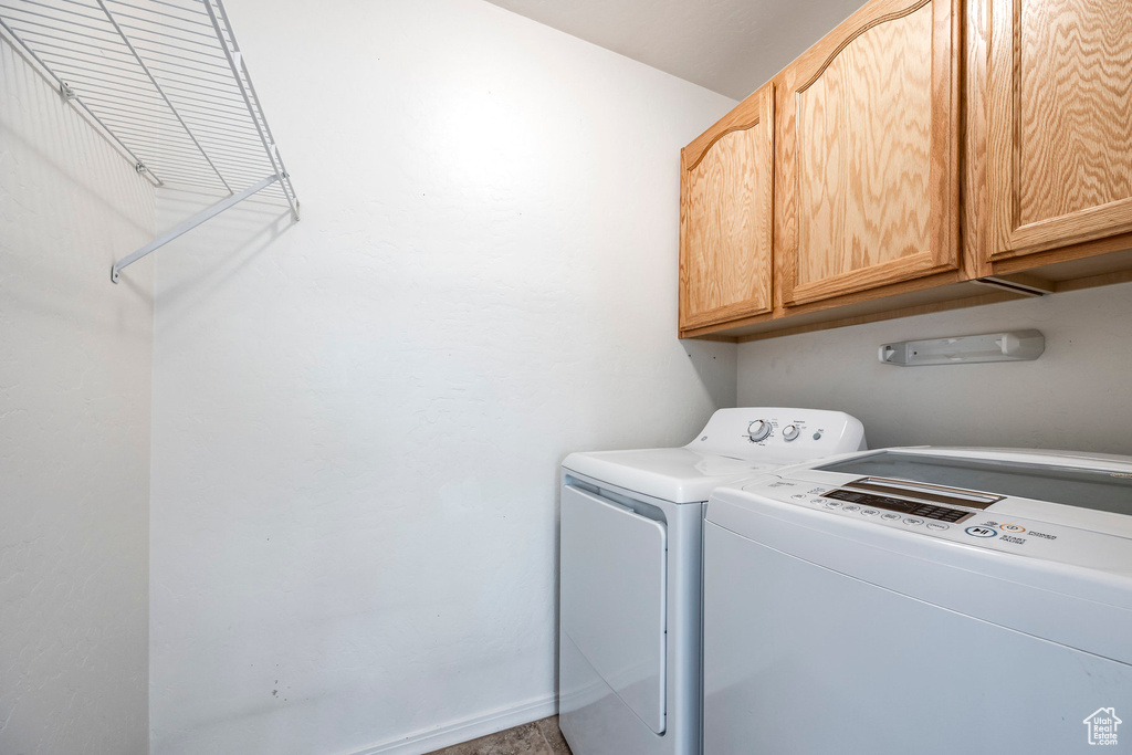 Laundry room with cabinet space, washer and clothes dryer, and baseboards