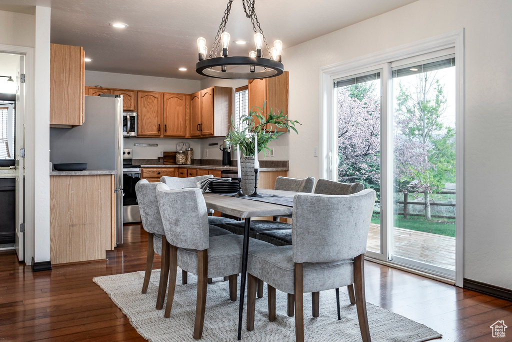 Dining room with a chandelier, dark wood finished floors, and recessed lighting