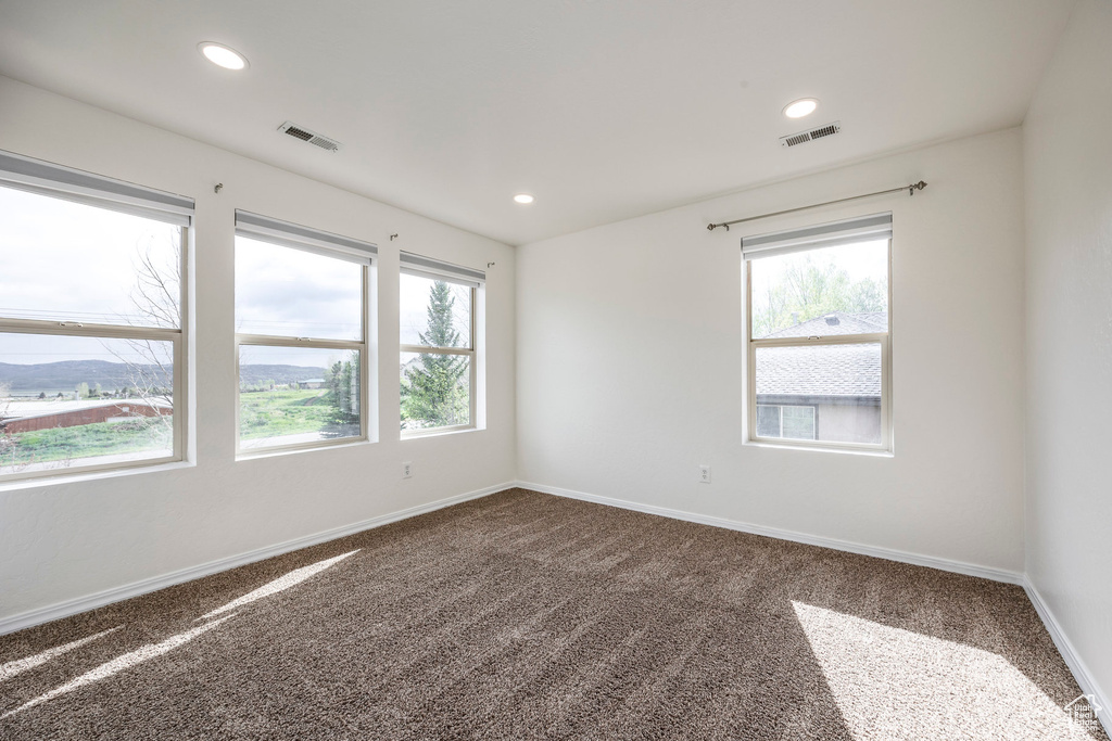 Carpeted empty room featuring healthy amount of natural light, baseboards, and recessed lighting