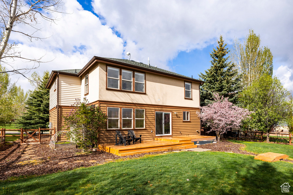 Rear view of property featuring a deck and stucco siding