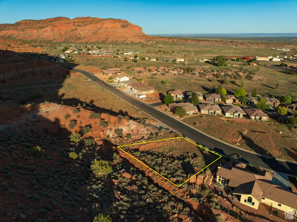 Aerial view of residential area with property parcel outlined and a mountain backdrop