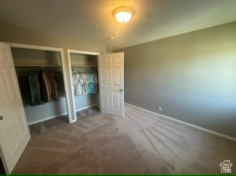 Unfurnished bedroom featuring multiple closets and baseboards