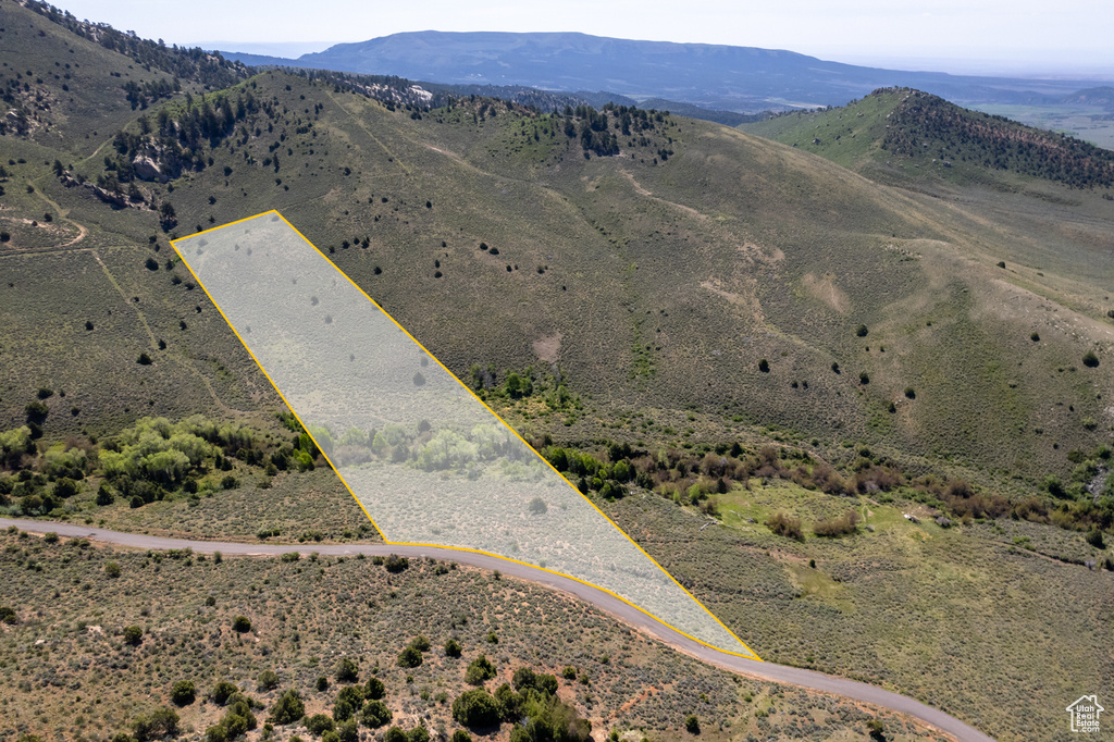 Aerial overview of property's location with a mountain backdrop and property boundaries highlighted