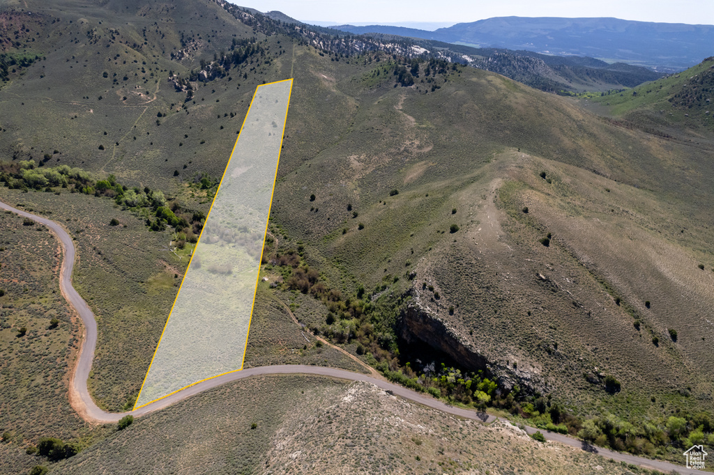 Aerial overview of property's location featuring a mountainous background and property parcel outlined
