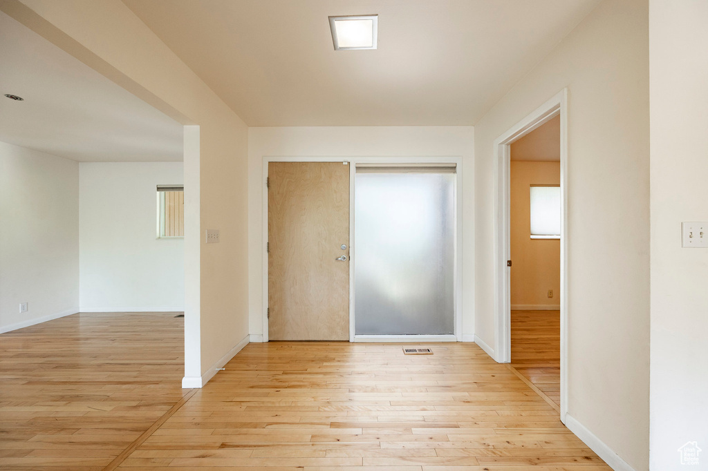 Corridor with light wood-style floors and baseboards