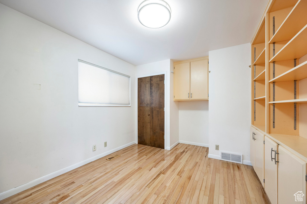 Spare room featuring light wood-style flooring and baseboards