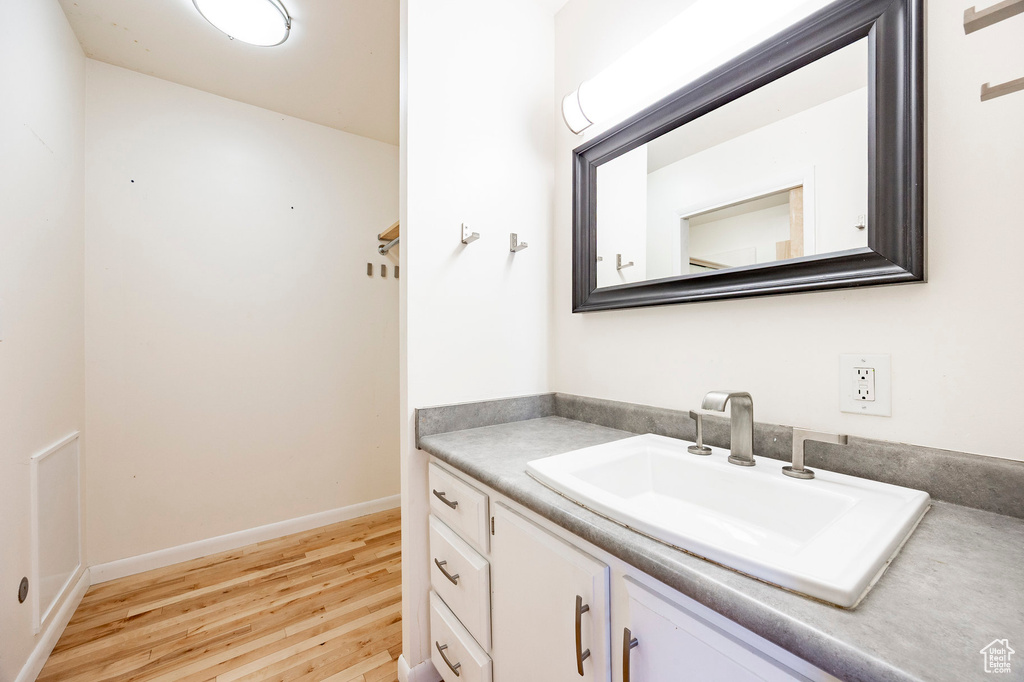 Bathroom featuring wood finished floors, vanity, and baseboards