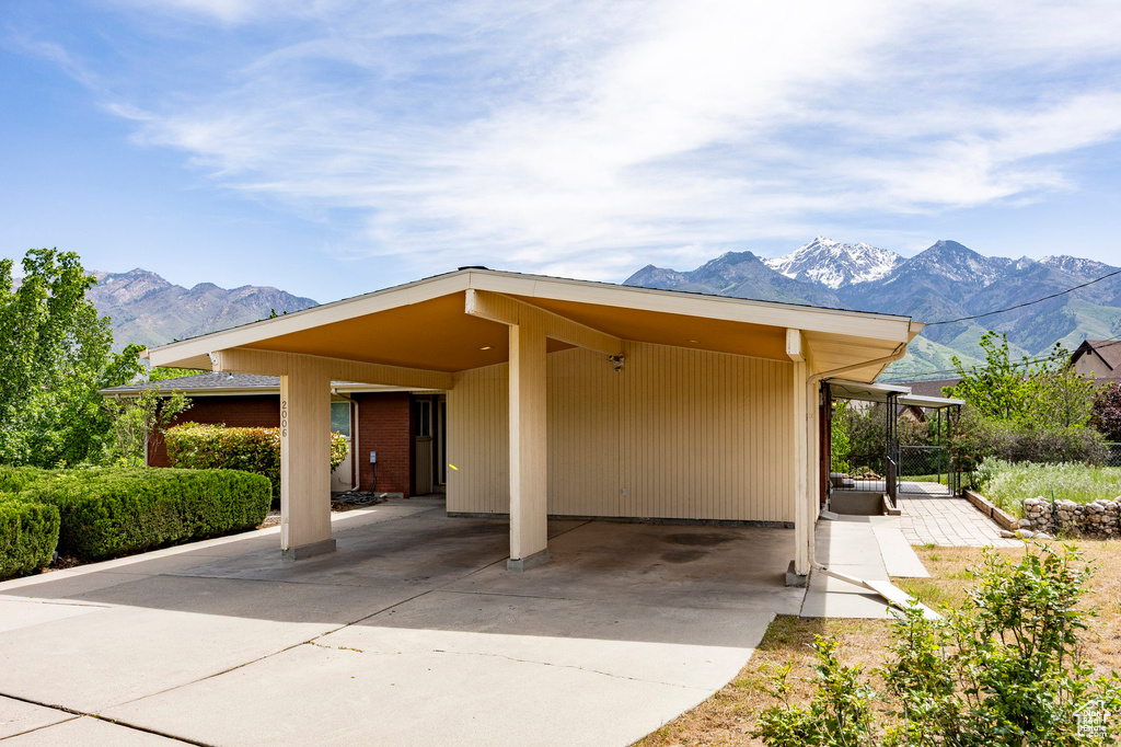 View of front of property featuring a mountain view, an attached carport, and concrete driveway
