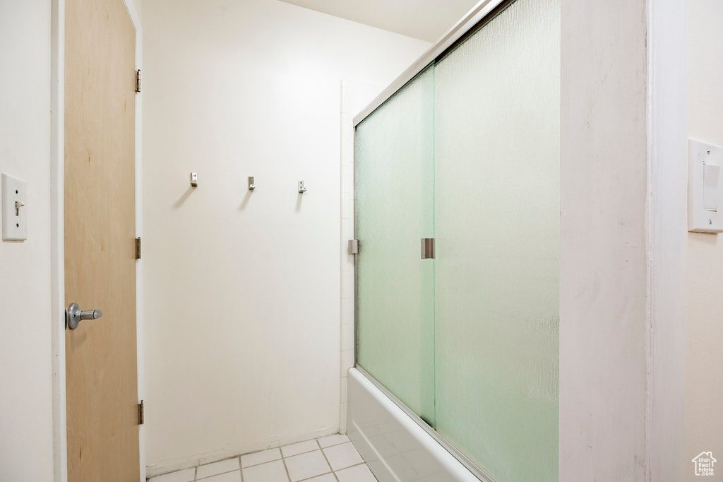 Full bathroom with tile patterned flooring and enclosed tub / shower combo