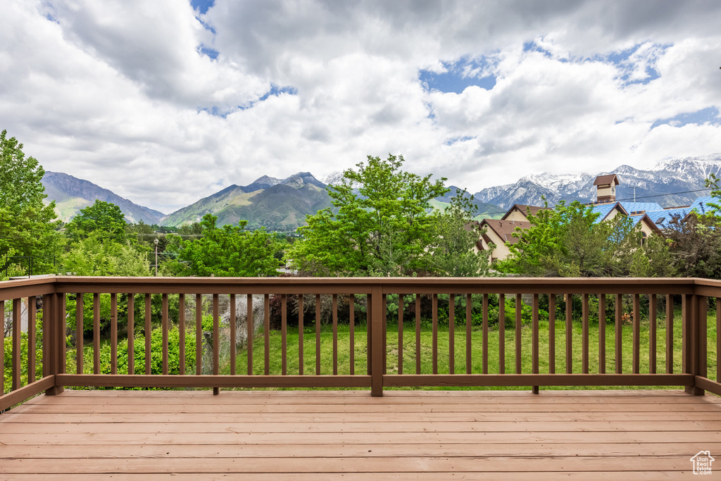 Deck featuring a mountain view and a lawn