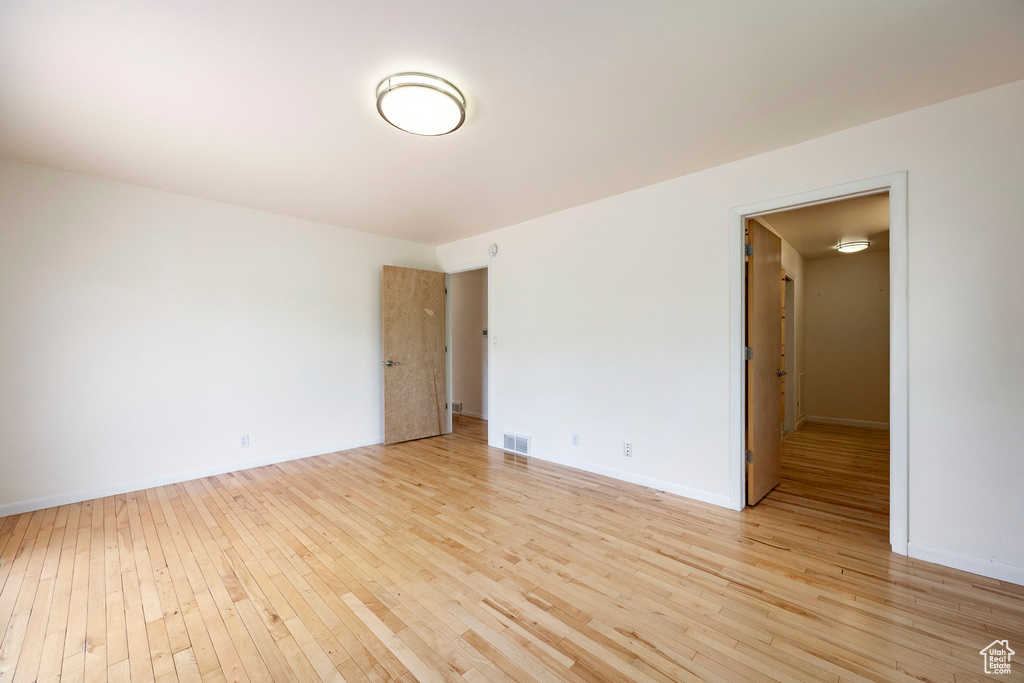 Spare room featuring light wood-type flooring and baseboards