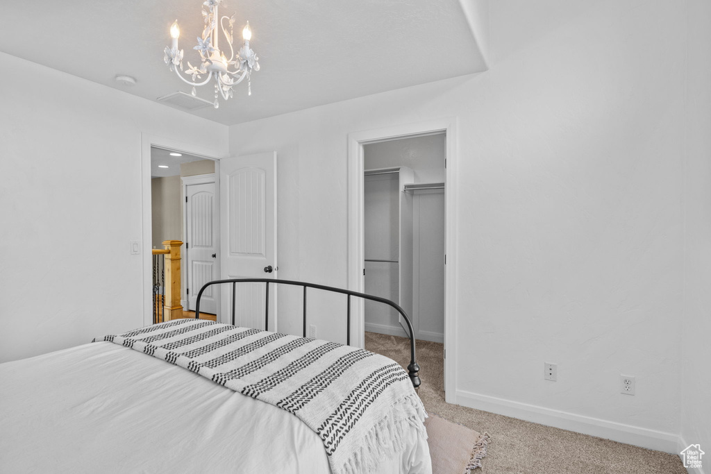 Bedroom with carpet, baseboards, a chandelier, a spacious closet, and a closet