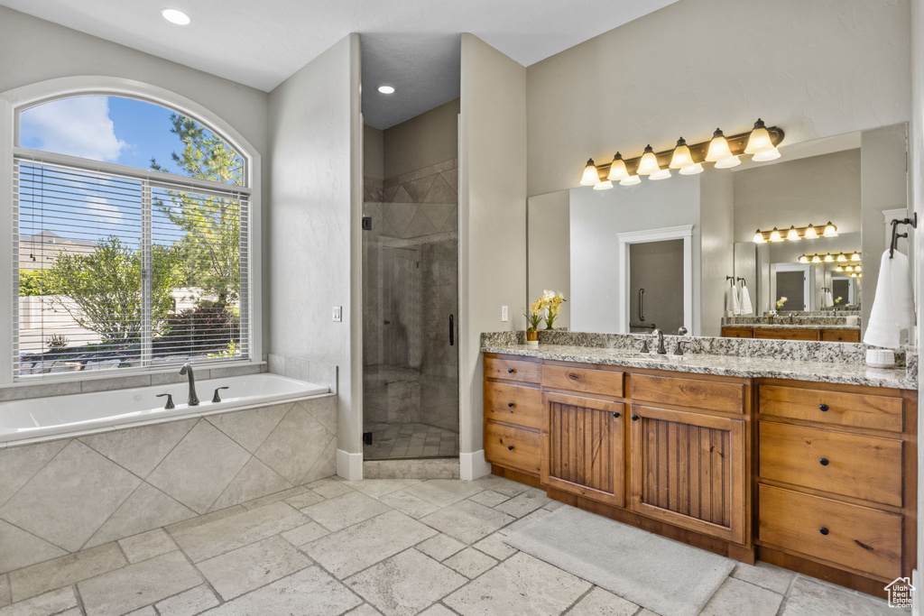 Full bath with vanity, a garden tub, plenty of natural light, a shower stall, and recessed lighting