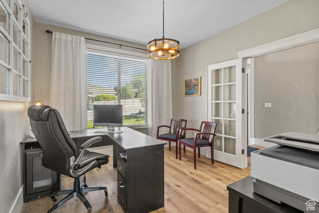 Office space with a chandelier and light wood-style floors