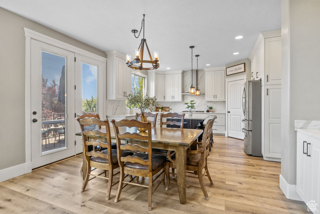 Dining area featuring a chandelier, light wood-style flooring, recessed lighting, and baseboards