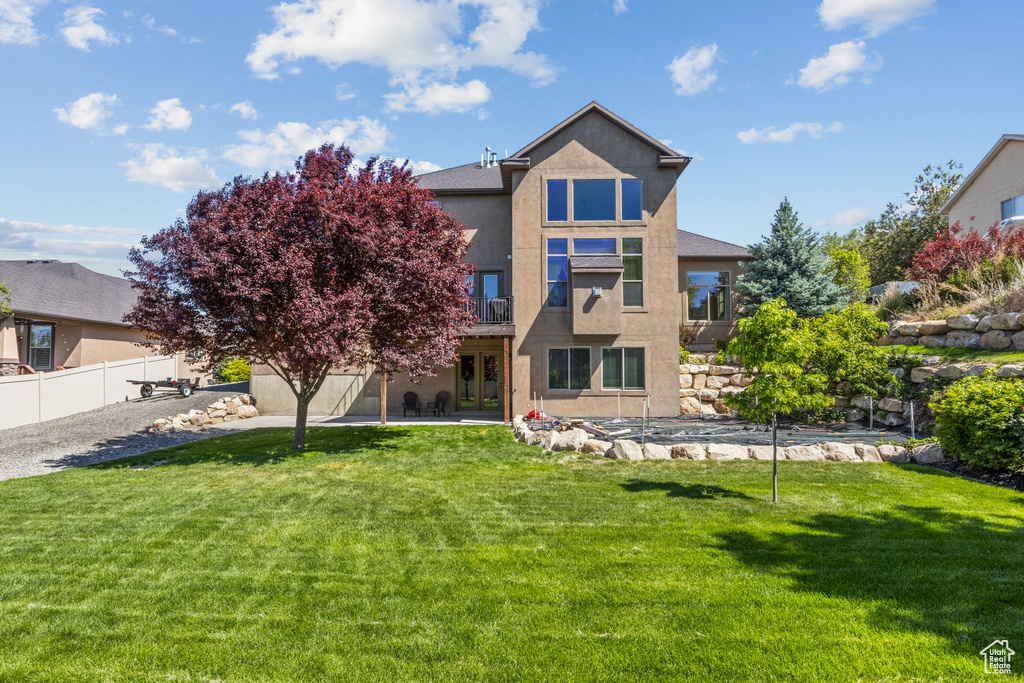 Rear view of property featuring french doors, stucco siding, and a patio