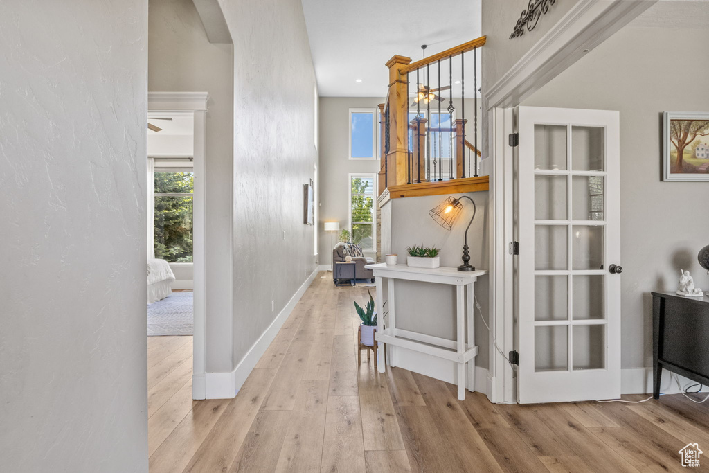 Hall featuring arched walkways, wood finished floors, healthy amount of natural light, and baseboards