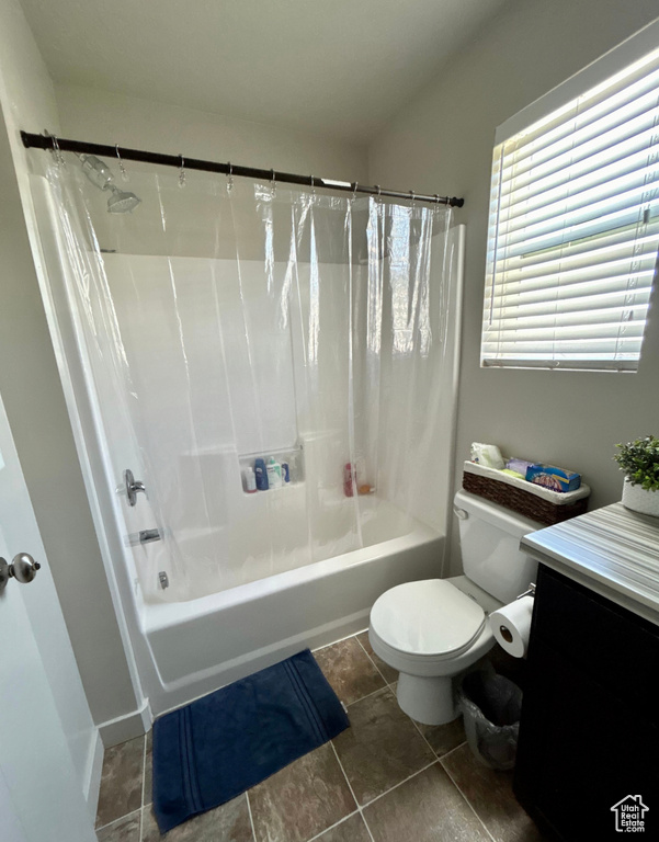 Bathroom with toilet, vanity, shower / bath combo, and tile patterned flooring